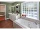 Bright bathroom with double sinks, jetted tub under a glass block window at 1648 Secessionville Rd, Charleston, SC 29412