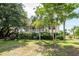 Charming raised beach house with a front porch, surrounded by mature trees and lush landscaping at 1648 Secessionville Rd, Charleston, SC 29412