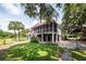 Elevated home with a screened-in porch, lush lawn, mature trees, and a basketball court at 1648 Secessionville Rd, Charleston, SC 29412
