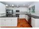 Well-lit kitchen featuring white cabinets, stainless steel appliances, and black countertops at 1648 Secessionville Rd, Charleston, SC 29412