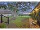 Landscaped backyard with a brick path, lawn and a decorative water fountain with rocks, next to a large tree and fence at 1673 Mcclain St, Charleston, SC 29407