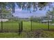 Spacious backyard with a black metal fence, green lawn, and a partial view of the water at 1673 Mcclain St, Charleston, SC 29407