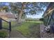 Landscaped backyard featuring a brick path and a decorative water fountain with rocks, next to a large tree and fence at 1673 Mcclain St, Charleston, SC 29407