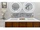 Bathroom featuring a double sink vanity, modern faucets, and lighted mirrors at 1673 Mcclain St, Charleston, SC 29407