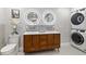 Modern bathroom featuring a double vanity, stackable washer and dryer, and gray flooring at 1673 Mcclain St, Charleston, SC 29407