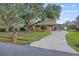 Charming single-story brick home featuring a covered carport and a lush front yard with mature trees at 1673 Mcclain St, Charleston, SC 29407
