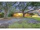 Quaint single-story brick home with mature trees, a long driveway, and a well-manicured lawn at 1673 Mcclain St, Charleston, SC 29407
