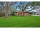 Charming brick home with manicured lawn, mature trees, and covered parking showcasing curb appeal at 1673 Mcclain St, Charleston, SC 29407