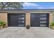 Modern two-car garage with sleek black doors and brick accents, complemented by potted plants at 1673 Mcclain St, Charleston, SC 29407