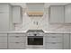 Close up of the gourmet kitchen featuring a professional-grade stainless steel stove and stylish grey cabinetry at 1673 Mcclain St, Charleston, SC 29407