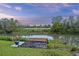 Scenic view of a private wooden dock and tranquil waterfront at sunset, with lush greenery at 1673 Mcclain St, Charleston, SC 29407