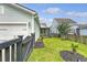 Backyard view of the home, garage, and fence, with green grass and mulch at 1822 Grovehurst Dr, Charleston, SC 29414