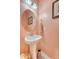 Charming powder room with pedestal sink, decorative mirror, and coral-colored walls at 1822 Grovehurst Dr, Charleston, SC 29414