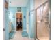Light-filled main bathroom featuring tiled floors, a walk-in shower, and an open doorway to the walk-in closet at 1822 Grovehurst Dr, Charleston, SC 29414