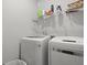 Bright laundry room with white washer and dryer, storage shelving, and organized laundry supplies at 201-B Mcmakin Dr, Summerville, SC 29483