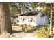 Charming white home nestled among mature trees, featuring a welcoming arched porch and manicured landscaping at 203 Weiters St, Walterboro, SC 29488