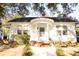Charming white home with unique arched porch, brick accents, and beautiful landscaping at 203 Weiters St, Walterboro, SC 29488