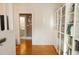 Hallway with hardwood floors, coat hooks, and built-in shelves with glass doors at 203 Weiters St, Walterboro, SC 29488