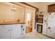 Bright kitchen with white cabinets, appliances, and a view into a dining area with chandelier and table at 203 Weiters St, Walterboro, SC 29488