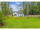 Backyard view of a home with a fenced yard, lush greenery, pool and spa, perfect for outdoor enjoyment and privacy at 206 Almond Ct, Summerville, SC 29483