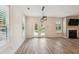 Open-concept living room with hardwood floors, a fireplace, a modern light fixture, and French doors leading to a pool at 206 Almond Ct, Summerville, SC 29483
