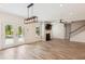 Spacious living room features a fireplace, a ceiling fan, a modern light fixture, and stairs to the second floor at 206 Almond Ct, Summerville, SC 29483