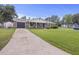 Inviting single-story home with a brick facade, long driveway, and lush green lawn at 212 Columbia Dr, Ladson, SC 29456
