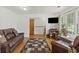 Cozy living room with laminate flooring, a leather sofa, and a flat-screen television at 212 Columbia Dr, Ladson, SC 29456