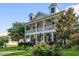Charming two-story home with a spacious porch, ceiling fans, and landscaped front yard at 216 Foxbank Plantation Blvd, Moncks Corner, SC 29461