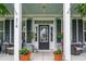 Inviting front porch with potted plants, comfortable seating, and a stylish entrance door at 216 Foxbank Plantation Blvd, Moncks Corner, SC 29461