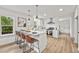Modern kitchen boasts white cabinets, stainless steel appliances, and a spacious island with bar seating at 217 Quaker Rd, Saint George, SC 29477