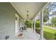 Inviting front porch with classic columns, seating, and stylish lighting fixture at 217 Quaker Rd, Saint George, SC 29477