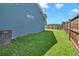 Side view of the house's siding and backyard with a wooden fence at 224 Sugarhouse Ct, Moncks Corner, SC 29461