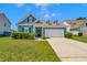 Charming blue home with manicured landscaping, dormers, and a two-car garage at 224 Sugarhouse Ct, Moncks Corner, SC 29461