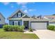 Charming blue home with manicured landscaping, dormers, and a two-car garage at 224 Sugarhouse Ct, Moncks Corner, SC 29461