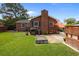 Spacious brick home backyard with a patio, fire pit, grill, and lush green lawn at 2651 Martha Dr, North Charleston, SC 29405
