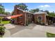Exterior shot of a brick home highlighting its expansive backyard with patio, garden and outdoor seating at 2651 Martha Dr, North Charleston, SC 29405
