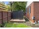 Modern backyard shed with a wooden base next to a brick house at 2651 Martha Dr, North Charleston, SC 29405