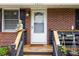 Charming brick home entrance with a white door, a Buddha statue, and a well-kept porch at 2651 Martha Dr, North Charleston, SC 29405