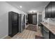 Open-concept kitchen with stainless steel refrigerator and dark cabinets, leading to the front door at 2651 Martha Dr, North Charleston, SC 29405