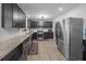 Modern kitchen with stainless steel appliances, dark cabinets, granite countertops, and wood-look flooring at 2651 Martha Dr, North Charleston, SC 29405