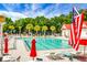Community pool featuring clear blue water, lounge chairs, and red umbrellas under a sunny sky at 2701 Four Winds Pl, Mount Pleasant, SC 29466