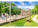 Community playground surrounded by mature trees featuring a climbing area, swings and slides at 2701 Four Winds Pl, Mount Pleasant, SC 29466