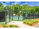 A fenced tennis court with a view of the surrounding landscaping and trees offers a private, quiet recreational area at 2701 Four Winds Pl, Mount Pleasant, SC 29466