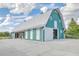 Modern green barn with large sliding doors and an open-air structure at 310 Marchman St, Summerville, SC 29486