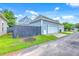 Detached garage with white door, and partial driveway, surrounded by green grass under a blue, partly cloudy sky at 310 Marchman St, Summerville, SC 29486