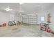 Spacious garage with a roll-up door, and a side door, with concrete flooring, tools and various items stored neatly at 310 Marchman St, Summerville, SC 29486