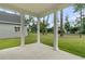 Covered back porch with white columns overlooking green lawn and trees, seamlessly blending indoor and outdoor living at 3222 Pinewood Dr, Ladson, SC 29456