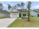 Charming one story home with white siding, black roof, and manicured lawn in a Gathering-friendly neighborhood at 3222 Pinewood Dr, Ladson, SC 29456