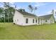 Charming rear exterior featuring a white siding, a covered porch, and a well-manicured lawn at 3222 Pinewood Dr, Ladson, SC 29456